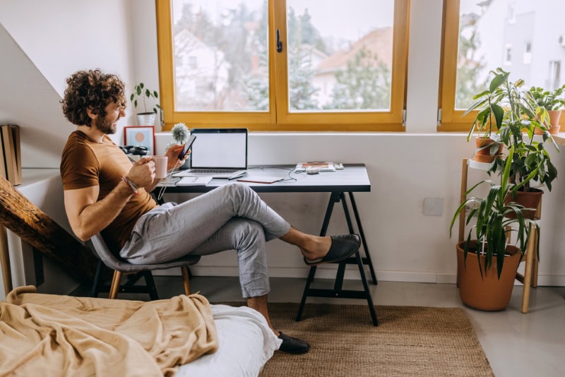 Male homeowner talking on phone about when to buy a heat pump.